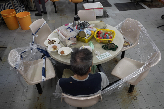 29일 홍콩의 한 레스토랑에서 사회적 거리두기 수칙이 적용된 탁자에서 한 손님이 식사를 하고 있다./AP연합뉴스