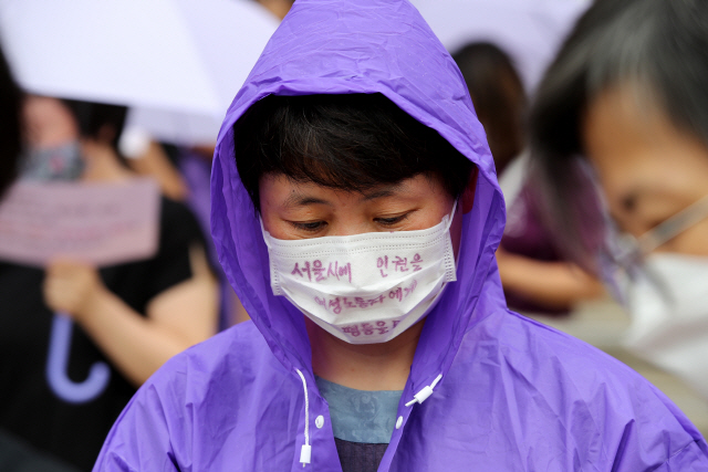 서울시 인권 및 평등 촉구 공동행동 회원이 28일 오전 서울 중구 서울도서관 앞에서 열린 ‘서울시장 위력에 의한 성폭력 국가인권위원회 직권조사 촉구 기자회견’에서 ‘서울시 인권을 여성노동자에게 평등을’이라는 문구가 적힌 마스크를 쓰고 있다./연합뉴스