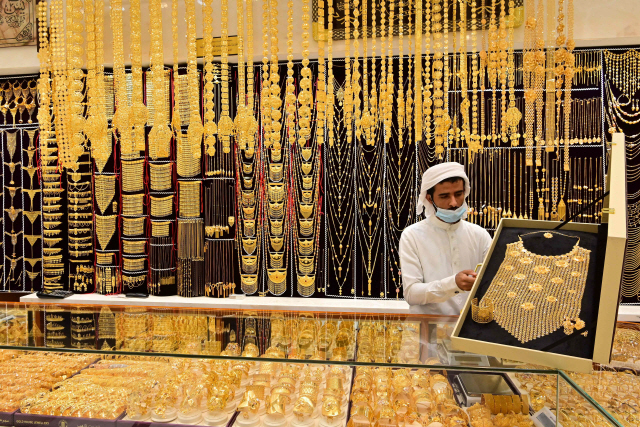 29일(현지시간) 아랍에미리트(UAE) 두바이에서 한 보석상이 가게에 금 장신구를 진열하고 있다. 이날 뉴욕상품거래소에서 8월 인도분 금은 전날보다 온스당 0.5%(8.80달러) 오른 1,953.40달러에 거래를 마치며 4거래일 연속 최고가 기록을 갈아치웠다.  /AFP연합뉴스