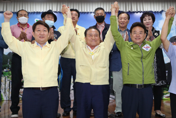 30일 오후 경북 군위군청에서 권영진 대구시장(왼쪽부터), 김영만 군위군수, 이철우 경북지사가 대구통합 신공항 이전지를 공동후보지로 신청할 것을 조건부 합의 후 가진 기자회견에서 함께 손을 들어 보이고 있다.   /군위=연합뉴스