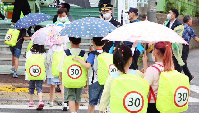 지난 28일 충남 서산시 부춘초등학교 앞 횡단보도에서 어린이들이 ‘30’이란 숫자가 적힌 노란색 안전덮개를 씌운 책가방을 메고 등교하고 있다. /서산=연합뉴스