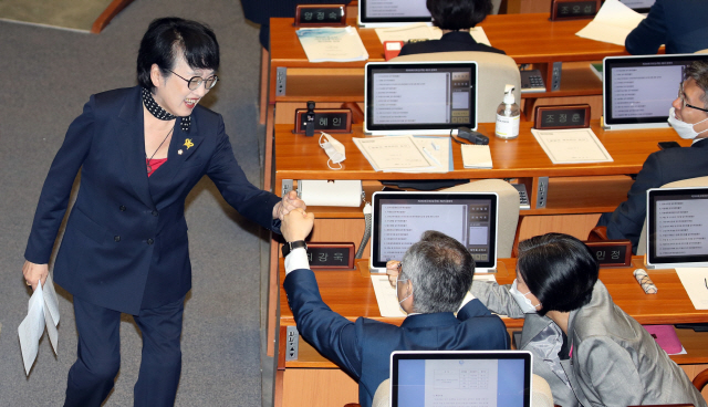 열린민주당 김진애 의원 4일 오후 국회 본회의에서 토론을 하고 자리로 향하며 최강욱 대표와 주먹 치기를 하고 있다. /연합뉴스