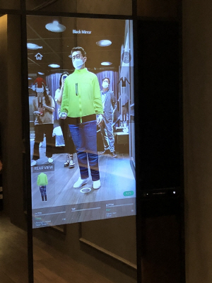 LG디스플레이 관계자가 4일 오픈이노베이션 OLED 쇼룸에서 피팅미러 역할을 하는 OLED 패널을 활용해 옷을 고르고 있다./이수민기자