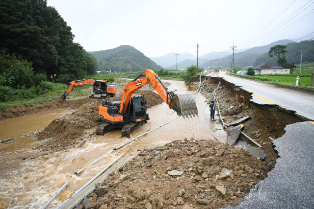 충남 예산군이 중장비를 동원해 집중호우로 파손된 도로와 제방을 복구하고 있다. 사진제공=연합뉴스