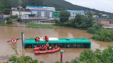 6일 오전 경기 파주시의 한 도로에서 시내버스가 물에 잠겨 구조 대원들이 승객들을 구조하고 있다./사진=연합뉴스