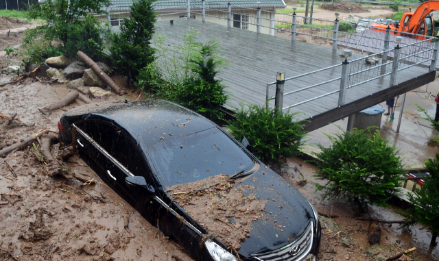 집중호우가 내린 4일 강원 화천군 사내면에서 토사가 흘러내려 차량이 묻히는 피해가 발생했다. /연합뉴스