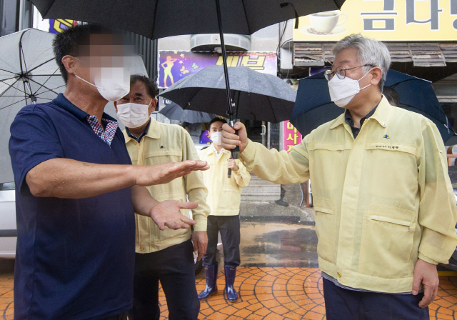 이재명 경기도지사가 3일 오후 여름휴가 일정을 취소하고 복귀해 안성시 집중호우 현장을 찾아 한 주민으로부터 피해 상황을 듣고 있다. /연합뉴스