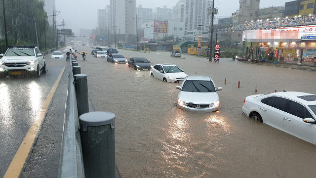 지난 3일 충남 천안시 신방동 홈플러스 앞 도로에 물이 들어차 차량들이 반쯤 잠겨 있다. /연합뉴스