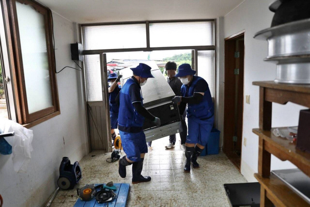 삼성전자서비스 직원들이 수해를 입은 경기도 연천군에서 침수됐던 냉장고를 꺼내고 있다./사진제공=삼성