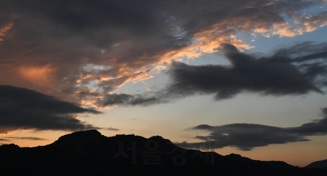 7일 오후 서울 종로구 하늘이 비구름이 잠시 걷히며 붉은 노을이 지고 있다. 중부지방은 8일 오후부터 9일까지 시간당 50∼100mm의 매우 강하고 많은 비가 내릴 것으로 예보됐다./오승현기자 2020.08.07