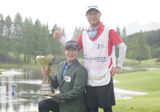 우승트로피를 든 김성현(왼쪽)이 캐디로 동반한 아버지와 함께 포즈를 취하고 있다. /사진제공=KPGA