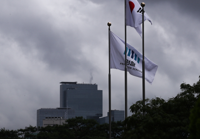 지난 7월 22일 서울 서초동 검찰 청사에 펄럭이는 깃발 너머로 삼성 서초사옥(왼쪽 아래)의 모습이 보이고 있다. /연합뉴스
