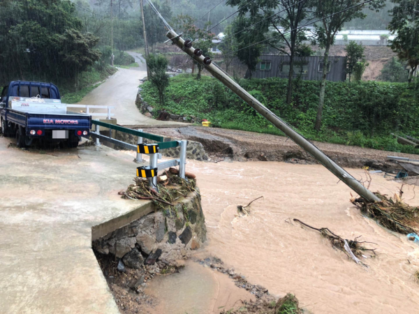 지난 8일 전남 담양군 담양읍 성도리의 한 도로가 불어난 물에 무너지고 전봇대가 쓰러져 있다./연합뉴스