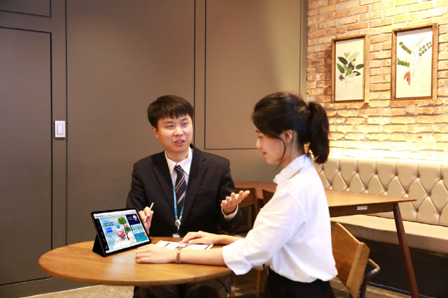 지난 7일 신협 직원(왼쪽)이 카페 매니저인 고객을 위해 카페를 직접 방문해 태블릿PC로 금융 서비스를 설명하고 있다./사진제공=신협