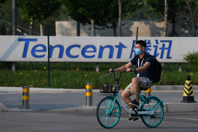 지난 7일 중국 베이징의 텐센트 본부 건물 앞을 마쓰크를 쓴채 자전거를 탄 사람이 지나가고 있다. /AFP연합뉴스