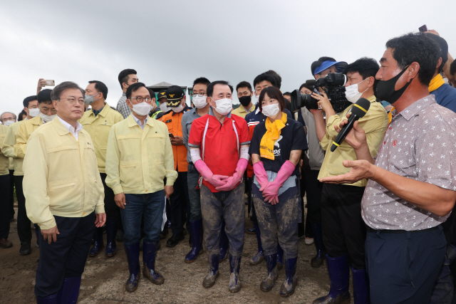 문재인 대통령이 12일 오후 집중 호우 피해를 입은 충남 천안시의 오이농장을 방문, 피해주민들과 간담회를 하고 있다./연합뉴스