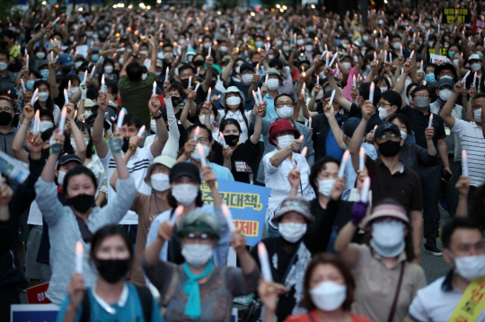 지난달 25일 오후 서울 중구 예금보험공사 앞에서 열린 ‘소급적용 남발하는 부동산 규제 정책 반대, 전국민 조세 저항운동 촛불집회’ 참가자들이 촛불을 들고 있다. /연합뉴스