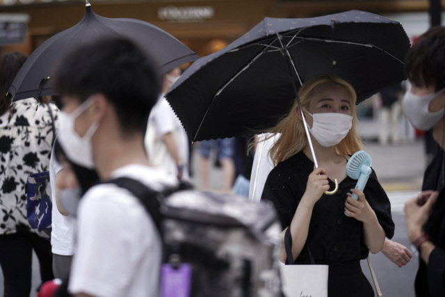 일본 도쿄 번화가인 시부야에서 13일 시민들이 마스크를 쓴 채 길을 걷고 있다. /AP연합뉴스
