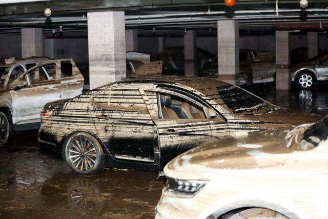 지난 10일 광주 북구의 한 아파트 단지의 100여대의 차량이 지하주차장을 매운 물이 이틀 만에 빠져 진흙이 잔뜩 묻은 차량의 모습이 드러나고 있다./연합뉴스