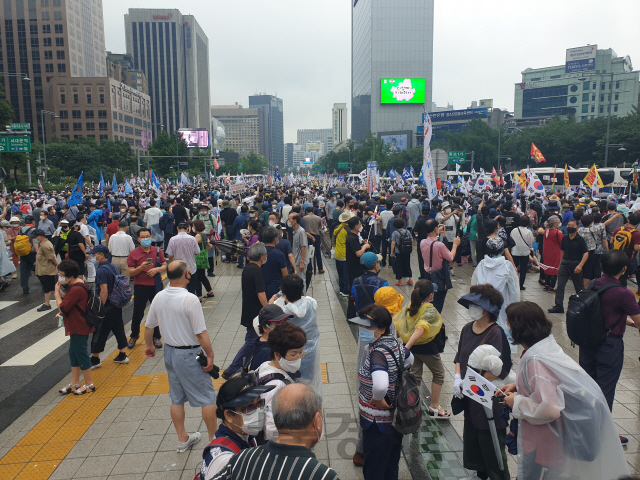 보수단체가 15일 오후 서울 종로구 세종대로 동화면세점 앞에서 개최한 집회에 참석한 이들이 도로로 나와 태극기를 흔들고 있다./허진기자
