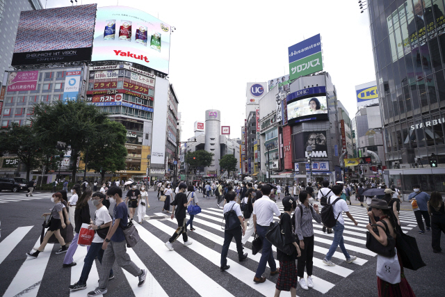 일본 시민들이 지난 13일 도쿄 시부야 거리를 걷고 있다. 신종 코로나 바이러스 감염증(코로나 19)으로 시민들 대부분이 마스크를 착용하고 있다.     /도쿄=AP연합뉴스