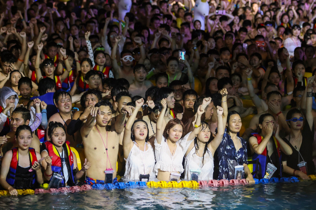 사람들이 15일(현지시간) 중국 후베이성 우한의 한 수영장에서 더위를 식히며 공연을 즐기고 있다. /AFP연합뉴스