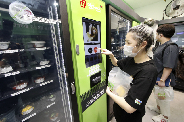 KT 기가에너지 매니저 프랜차이즈 플러스가 적용된 서울 마곡나루의 ‘잇다가게’에서 고객들이 자판기를 이용해 비대면으로 반찬을 구매하고 있다./사진제공=KT