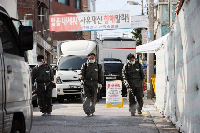 새마을지도자협의회 관계자들이 17일 오후 서울 성북구 사랑제일교회 인근에서 방역 작업을 하고 있다./연합뉴스