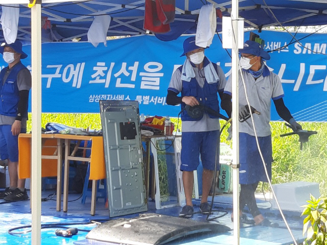 18일 전남 구례5일장에 마련된 삼성전자 수리센터의 직원들이 가전제품을 수리하고 있다.