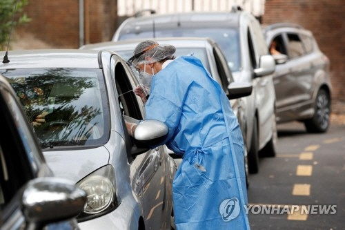 이탈리아 로마의 산 지노반니 병원에 마련된 신종 코로나바이러스 감염증(코로나19) 드라이브인 선별 진료소에서 18일(현지시간) 의료진들이 방문 차량의 운전자들을 상대로 검체를 채취하고 있다./로이터연합뉴스