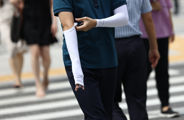 폭염이 기승을 부린 18일 오후 광화문네거리를 지나는 경찰이 팔 토시를 착용하고 있다. /연합뉴스