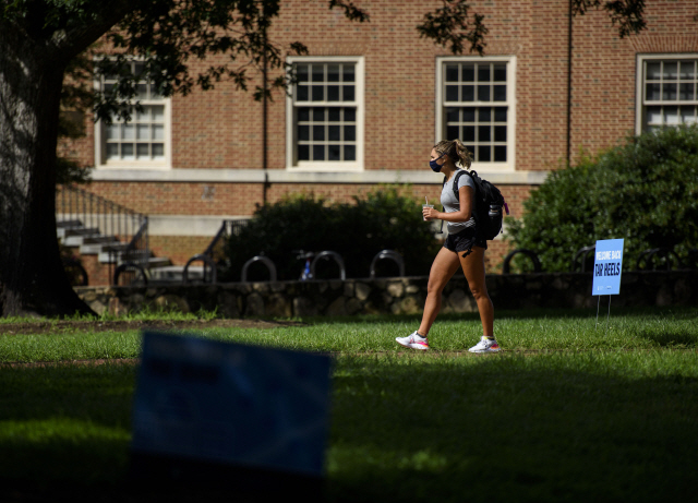 18일(현지시간) 마스크를 착용한 한 학생이 미국 노스캐롤라이나 대학 캠퍼스 안을 걷고 있다./AFP연합뉴스