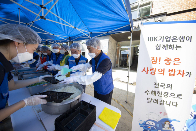 IBK기업은행 임직원 자원봉사단이 19일 충청북도 영동군에서 ‘사랑의 밥차’ 무료급식 봉사 활동을 하고 있다./사진제공=IBK기업은행