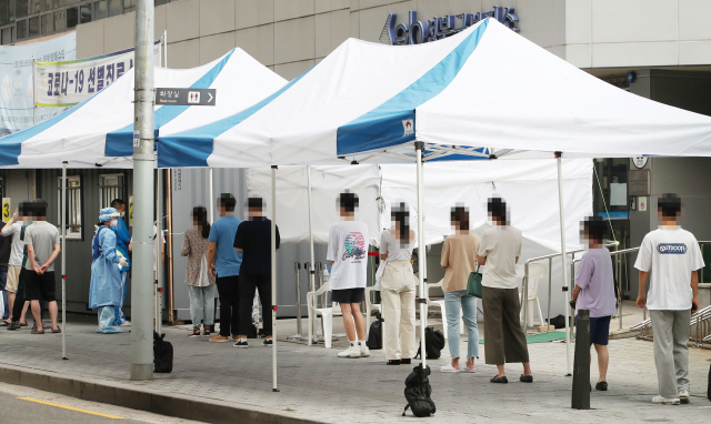 21일 오전 서울 성북구보건소에 마련된 신종 코로나바이러스 감염증(코로나19) 선별진료소를 찾은 시민들이 검사받기 위해 줄을 서고 있다./연합뉴스
