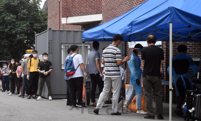 코로나19 신규 확진자가 300명대로 급증한 21일 오전 서울 종로구보건소에 마련된 컨테이너형 워킹스루 선별진료소에서 시민들이 코로나19 검사를 받고 있다. 이날 신규 확진자 324명은 지난 3월 8일 이후 166일 만에 첫 300명대 기록이자 가장 많은 수치다./오승현기자 2020.08.21