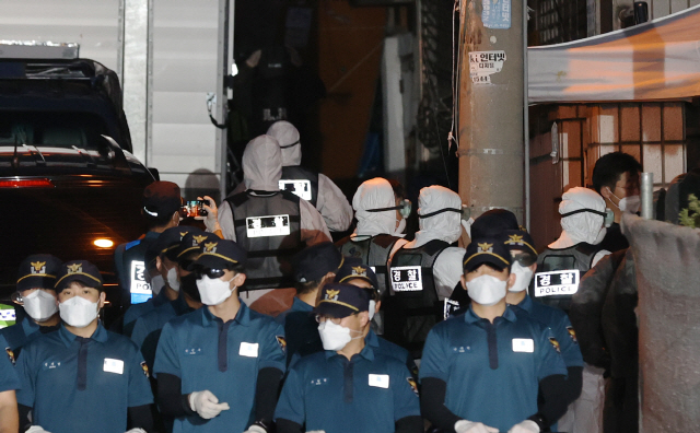 방호복을 입은 경찰관계자들이 21일 압수수색영장을 집행하기 위해 서울 성북구 사랑제일교회 입구로 이동하고 있다. /연합뉴스