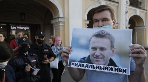 지난 20일(현지시간) 러시아 상트페테르부르크에서 한 남성이 독극물 중독 의심 증상으로 의식불명에 빠진 야권운동가 알렉세이 나발니의 사진을 든 채 그의 생존을 기원하며 시위를 벌이고 있다. /EPA연합뉴스