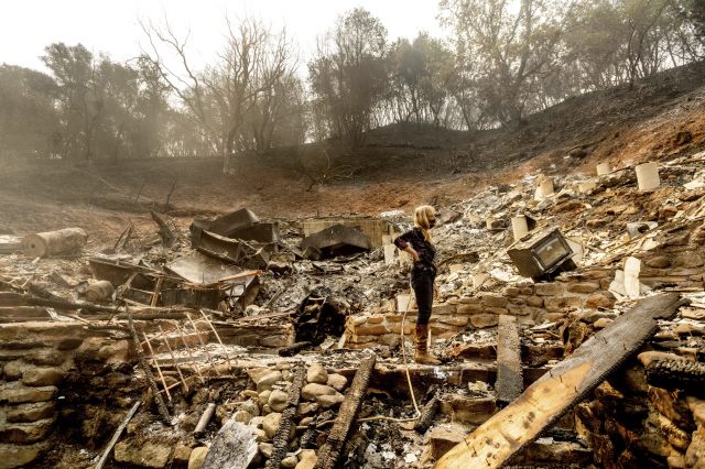대형 산불이 휩쓸고 지나간 미국 캘리포니아주 배커빌 지역에서 21일(현지시간) 한 주민이 전소한 주택 잔해더미를 살펴보고 있다. /AP연합뉴스.
