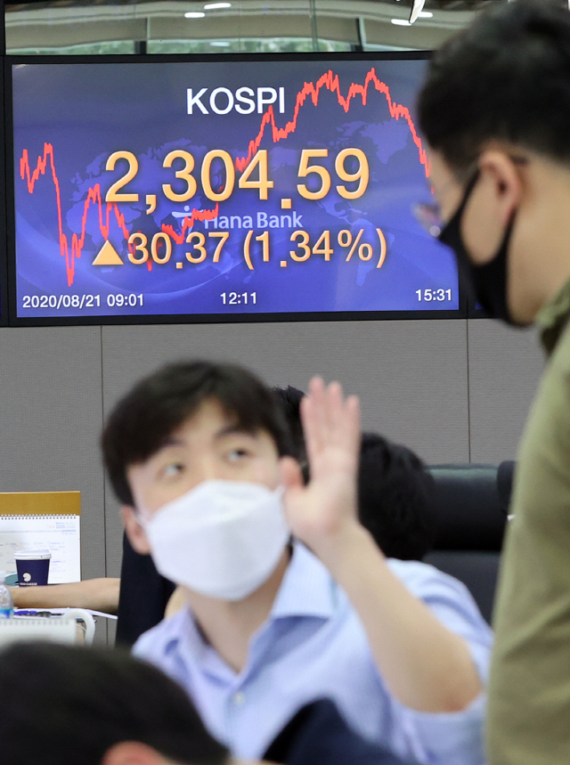 지난 21일 오후 서울 중구 하나은행 딜링룸에서 딜러들이 대화를 나누고 있다. 이날 코스피는 전날보다 30.37포인트(1.34%) 오른 2,304.59에 거래를 마쳤다./연합뉴스