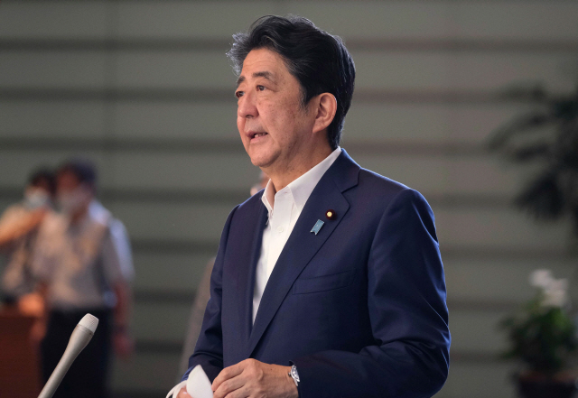 아베 신조 일본 총리가 사흘간의 여름 휴가를 마친 지난 19일 도쿄의 총리 관저로 출근하면서 취재진의 질문에 답하고 있다. /AFP연합뉴스
