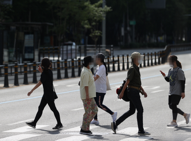 23일 오후 서울 광화문사거리에서 시민들이 마스크를 착용한 채 횡단보도를 건너고 있다. /연합뉴스