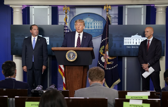 도널드 트럼프(가운데) 미국 대통령이 23일(현지시간) 백악관에서 열린 브리핑에서 스티븐 한(오른쪽) FDA 국장과 함께 코로나19 사태 전개 상황을 설명하고 있다. /로이터연합뉴스