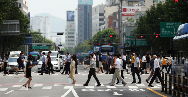 서울 전역 실내외에서 마스크를 의무로 착용해야 하는 행정명령이 발효된 24일 시민들이 서울 종로구 일대 횡단보도에서 마스크를 착용한 채 이동하고 있다./연합뉴스