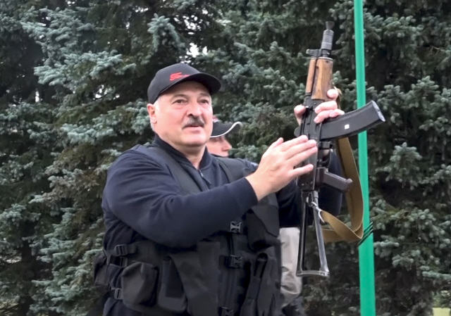 23일(현지시간) 알렉산드르 루카셴코 벨라루스 대통령이 자동소총을 들고 관저로 향하고 있다. /AP연합뉴스
