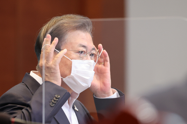 문재인 대통령이 24일 오후 청와대에서 열린 수석·보좌관 회의에서 발언에 앞서 마스크를 벗고 있다./연합뉴스