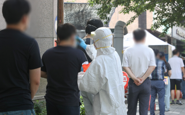 24일 오전 대전시 서구 보건소 앞에서 코로나19 진단검사를 받으려는 시민들이 검사에 앞서 발열 체크를 하고 있다./대전=연합뉴스