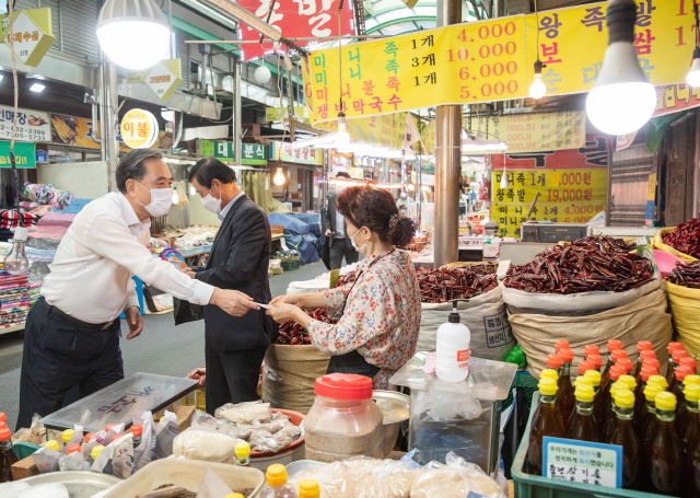 박차훈(왼쪽) 새마을금고중앙회장이 지난 24일 서울시 중랑구 면목시장을 찾아 물품을 구매하고 있다./사진제공=새마을금고중앙회