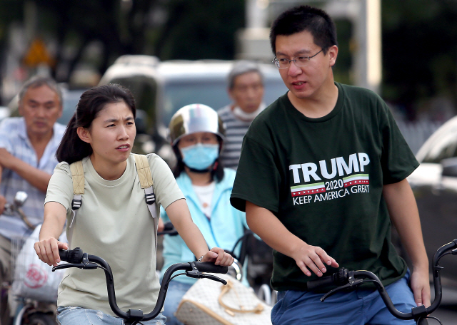 25일 중국 베이징 시민들이 마스크 없이 자전거를 타고 있다 한 남성의 티셔츠에 쓰인 ‘트럼프 지지’ 문구가 눈에 띈다. /UPI연합뉴스