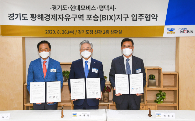 26일 경기도청에서 열린 현대모비스 전기차 핵심부품 공장 설립을 위한 황해경제자유구역 입주협약식에서 정장선(왼쪽부터) 평택시장, 이재명 경기도지사, 박정국 현대모비스 사장이 기념촬영을 하고 있다./사진제공=현대모비스