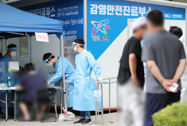 26일 서울 노원구 보건소에 설치된 코로나19 선별진료소를 찾은 시민들이 검체 채취를 받기 위해 접수하고 있다./연합뉴스